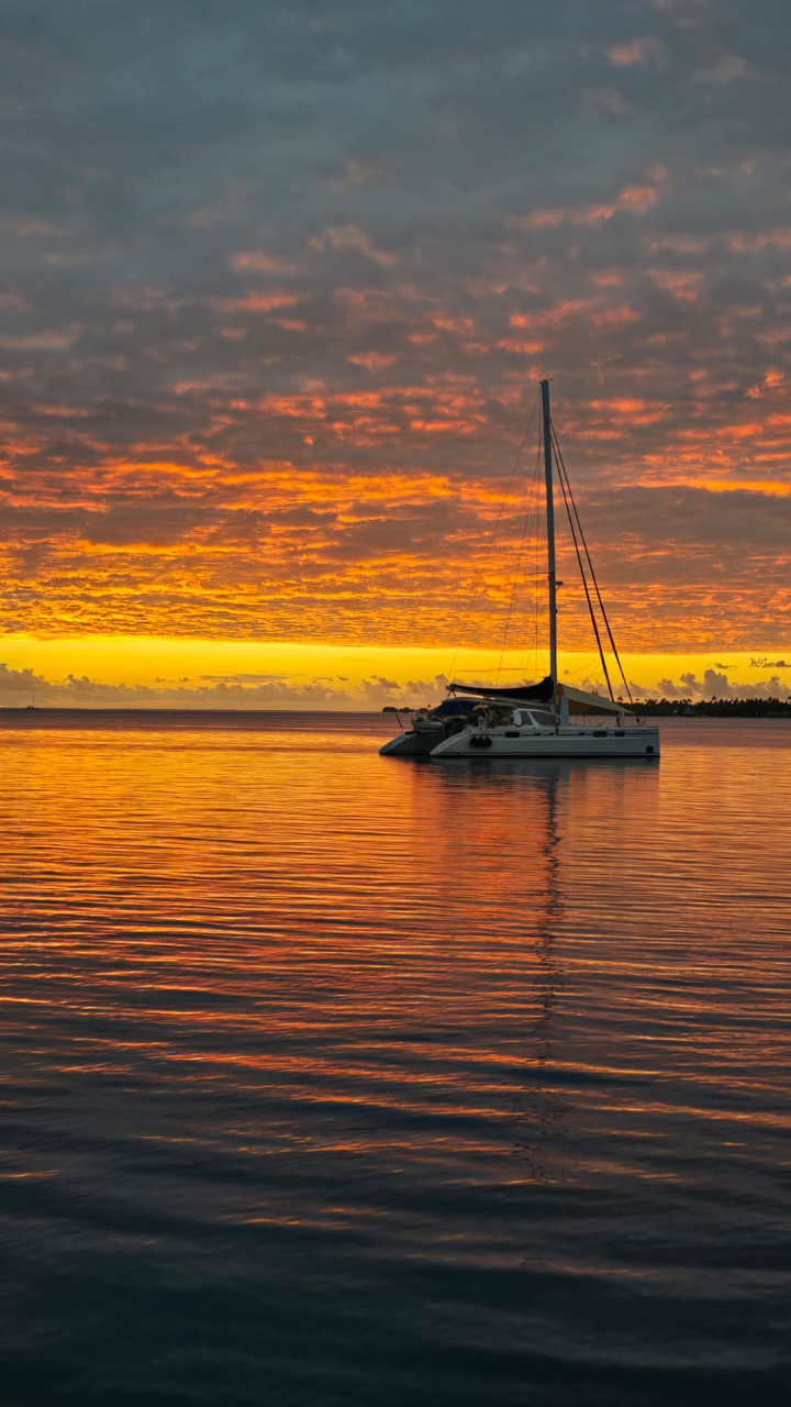 Catamaran au coucher du soleil dans les Tuamotu